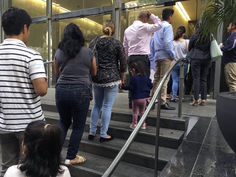 In this June 28, 2018, photo, people line up outside the building that houses the immigration courts in Los Angeles. In recent weeks, immigration judges have been thrust into the center of the heated political controversy over how the Trump administration is handling the cases of mostly Central American immigrants caught on southwest border. (AP Photo/Amy Taxin)