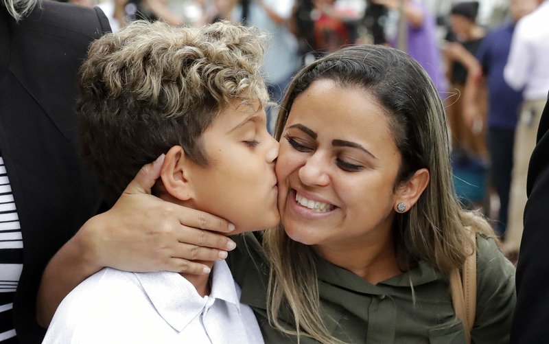 Diego Magalhaes, left, 10, kisses his mother Sirley Silveira, Paixao, an immigrant from Brazil seeking asylum with her son, after Diego was released from immigration detention, Thursday, July 5, 2018, in Chicago. 