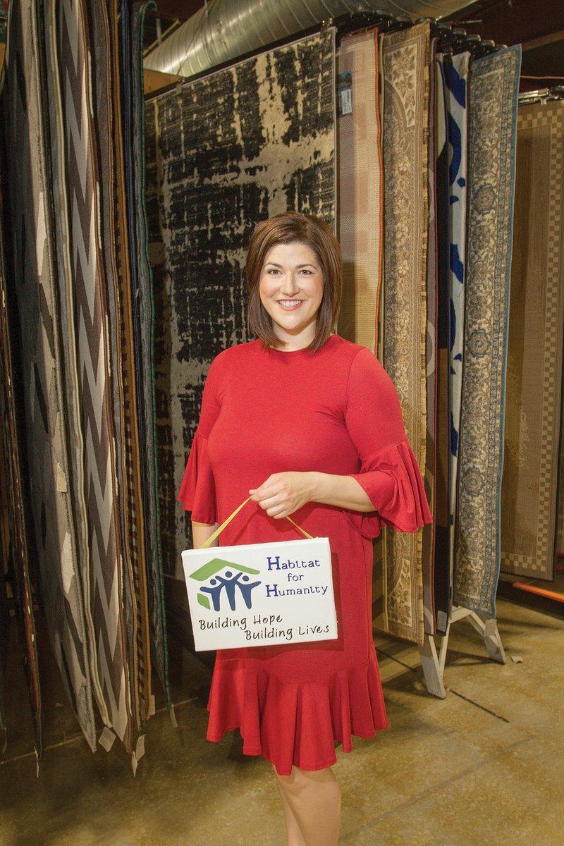 Angela Connell stands near area rugs in the back of the Habitat for Humanity of Independence County retail store in Batesville. Connell was hired as executive director for the local Habitat branch in March. She is a 2002 graduate of Batesville High School.