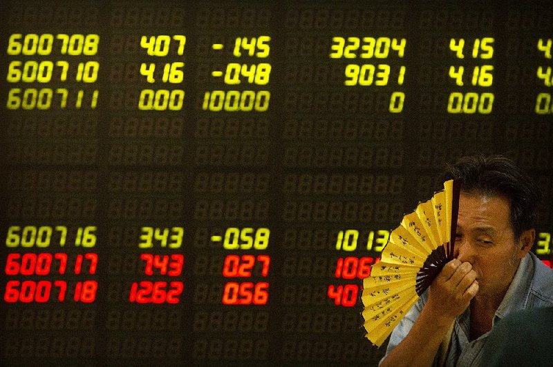 A Chinese investor keeps an eye on stock prices Friday at a brokerage house in Beijing. 