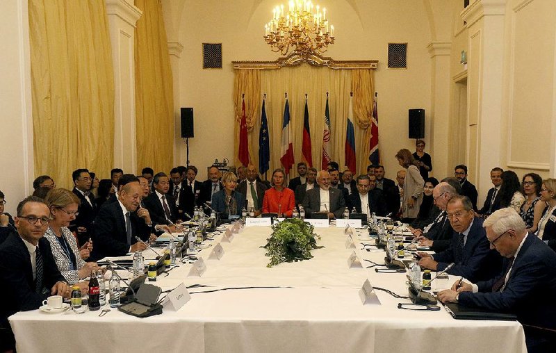 Delegates sit around a table prior to a bilateral meeting as part of the closed-door nuclear talks with Iran at a hotel in Vienna, Austria