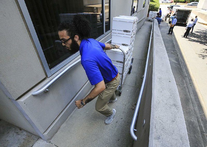 Jonas Crank unloads boxes of casino amendment petitions Friday outside the secretary of state’s office. 
