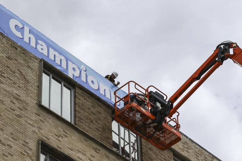 Workers put up a sign on the side of a building at Arkansas Children's Hospital in Little Rock on Wednesday, May 24, 2017.
