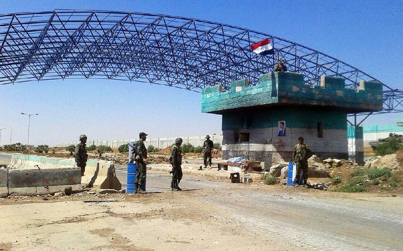 Syrian troops stand guard Saturday at the Naseeb crossing on the country’s border with Jordan.  