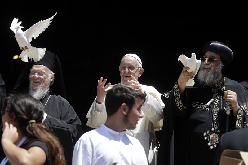 Pope Francis, center, flanked by Ecumenical Patriarch Bartholomew I, left, and Tawadros II, Pope of Alexandria and Patriarch of the See of St. Mark, free doves outside the St. Nicholas Basilica on the occasion of a daylong prayer for peace in the Middle East in Bari, southern Italy, Saturday, July 7, 2018.  (AP Photo/Gregorio Borgia)