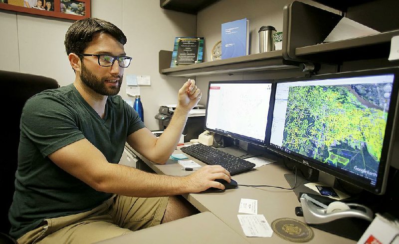 Grant Drawve looks over an aggravated assault risk terrain map of the city of Little Rock in his office on the University of Arkansas, Fayetteville campus. UA researchers, among others, are mapping where terrorist attacks have been planned in the United States.