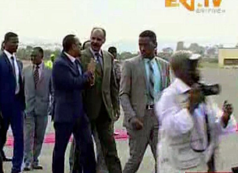 In this grab taken from video provided by ERITV, Ethiopia's Prime Minister Abiy Ahmed, centre left is welcomed by Erirea's President Isaias Afwerki as he disembarks the plane, in Asmara, Eritrea, Sunday, July 8, 2018. With laughter and hugs, the leaders of longtime rivals Ethiopia and Eritrea met for the first time in nearly two decades Sunday amid a rapid and dramatic diplomatic thaw aimed at ending one of Africa's longest-running conflicts. (ERITV via AP)