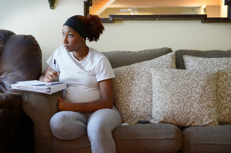 Sade Danie takes notes Friday while studying with the help of a DVD at Compassion House in Springdale. Danie is the first 18-year-old to move into Compassion House, a home for pregnant teens 
