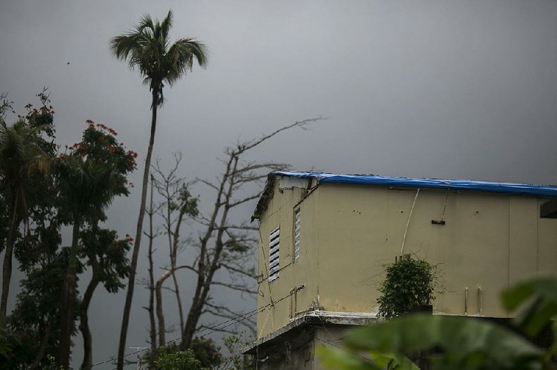 A tarp serves as the roof of a home in Yabucoa, Puerto Rico, that was damaged last year by Hurricane Maria. The remnants of Tropical Storm Beryl passed over the region Monday. 