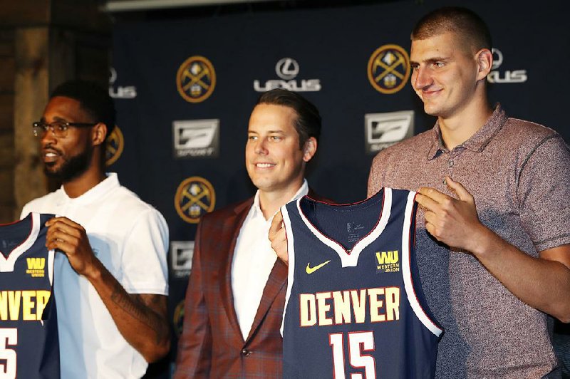 Denver Nuggets center Nikola Jokic (right) joins guard Will Barton (left) and Josh Kroenke, president of the Denver Nuggets, during a news conference Monday to outline a contract extension for Jokic and the re-signing of Barton.