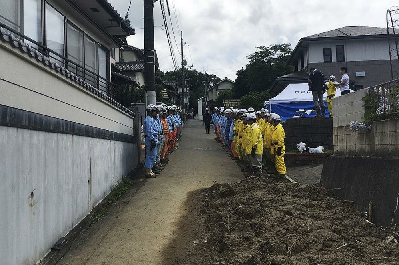 Emergency workers gather Monday in Hiroshima, Japan, as the search for flood victims continues. 