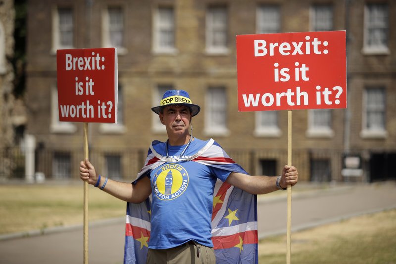 The Associated Press PRO-EU SIGNAGE: Anti-Brexit, pro-EU supporter Steve Bray holds placards on Abingdon Green across the road from the Houses of Parliament in London, Monday. Former U.K. Brexit Secretary David Davis said Monday that he won't seek to challenge Prime Minister Theresa May's leadership after resigning from her Cabinet, but will aim to pressure her to toughen her position on Britain's departure from the European Union.