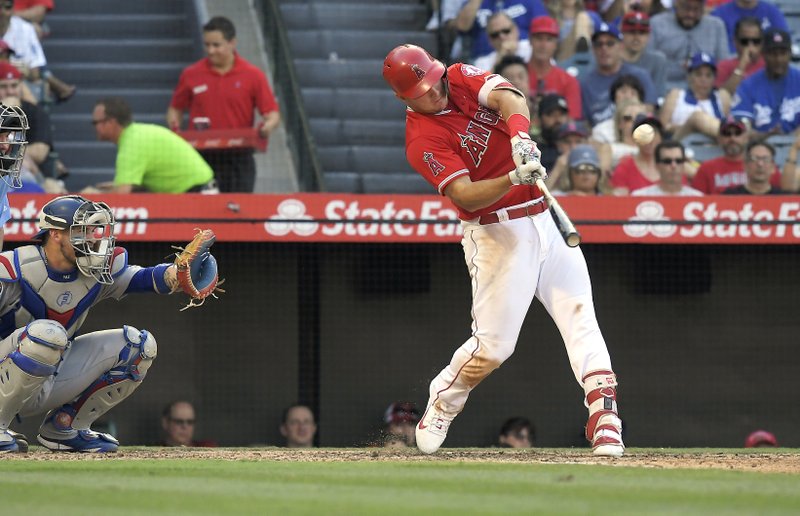 The Associated Press ALL-STAR SLUGGER: Los Angeles Angels' Mike Trout, right, hits a solo home run as Los Angeles Dodgers catcher Yasmani Grandal watches during the sixth inning Saturday in Anaheim, Calif. Trout leads the American League's outfield for the upcoming All-Star Game.