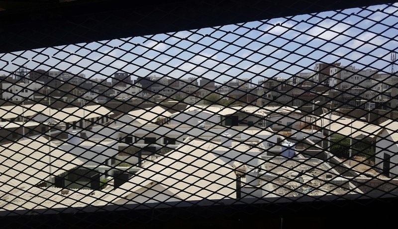 FILE - This May 9, 2017 file photo, shows a view through a mesh window over part of Aden Central Prison, known as Mansoura, in Aden, Yemen. A section of the prison is run by Yemeni allies of the United Arab Emirates, part of a network of secret prisons in southern Yemen. Yemen's deputy interior minister said secret prisons that the AP had reported are under the control of the United Arab Emiratis and its allied militias are now under the authority of the Yemeni government. However, other security officials contradicted the statement Monday, July 9, 2018, by Maj. Gen. Ali Lakhsha. (AP Photo/Maad El Zikry, File)