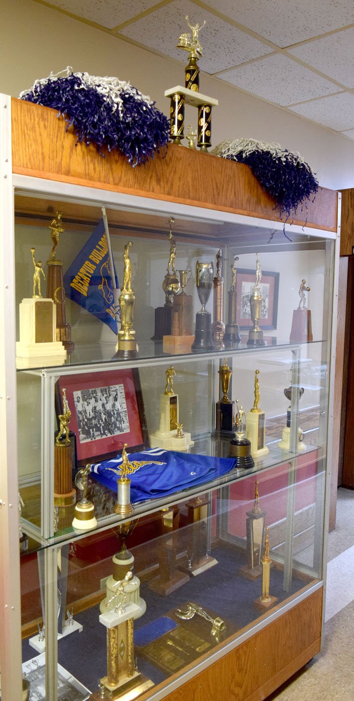 Westside Eagle Observer/MIKE ECKELS The new display case at Decatur City Hall contains trophies, plaques, a cheerleader's outfit, and other sports memorabilia from the 1939-1999 Decatur High School basketball, football and cheerleading programs.