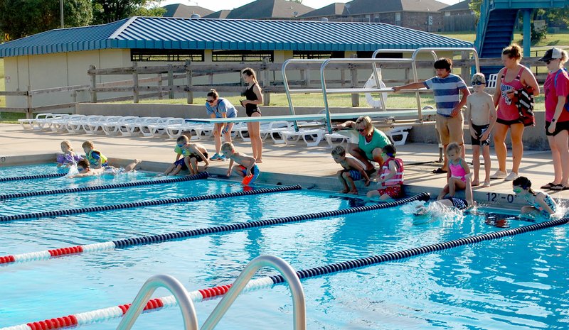 Hunter McFerrin/Herald-Leader Kids ages six and under kick off the day's events after jumping into the pool for the swimming portion of the race.