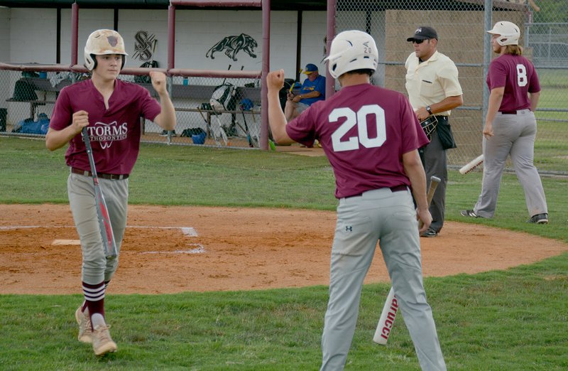 Graham Thomas/Herald-Leader Storms Orthodontics players Elijah Coffey, left, and Baron Meek celebrate after Coffey scored a run in the first inning of Monday's game. The game was called off after the first inning because of a heavy rainstorm.