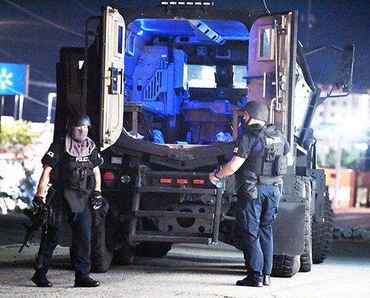 The Sentinel-Record/Grace Brown SWAT TEAM: Members of the Hot Springs Police Department's SWAT team exit the department's Mine Resistant Ambush Protected vehicle following the conclusion of a two-hour standoff with a suspect at Timbercrest RV & Mobile Home Park, 3921 Central Ave., Monday night.