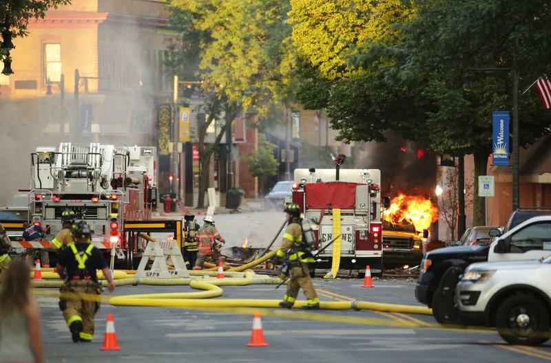 Firefighters work the scene of an explosion in downtown Sun Prairie, Wis., Tuesday, July 10, 2018. The explosion rocked the downtown area of Sun Prairie, a suburb of Madison, after a contractor struck a natural gas main Monday, sending an unknown number of people to hospitals, authorities said. (Amber Arnold/Wisconsin State Journal via AP)