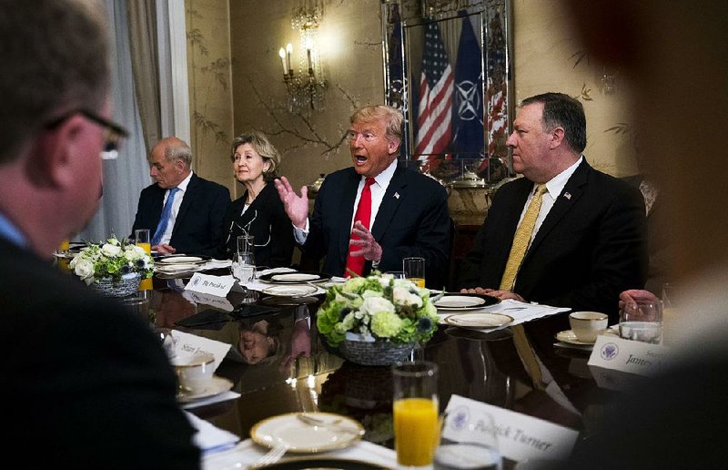 President Donald Trump addresses NATO Secretary-General Jens Stoltenberg (unseen) during a breakfast meeting Wednesday in Brussels also attended by Chief of Staff John Kelly (left), U.S. Ambassador to NATO Kay Bailey Hutchison and Secretary of State Mike Pompeo. 