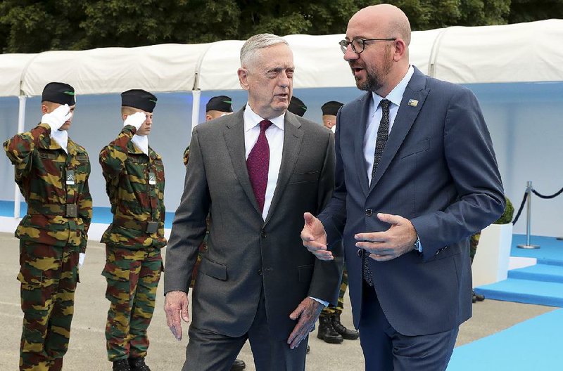 Defense Secretary James Mattis (left) talks with Belgian Prime Minister Charles Michel as they arrive Wednesday for an event in Brussels. The U.S. is pressuring NATO allies to spend more on defense.  