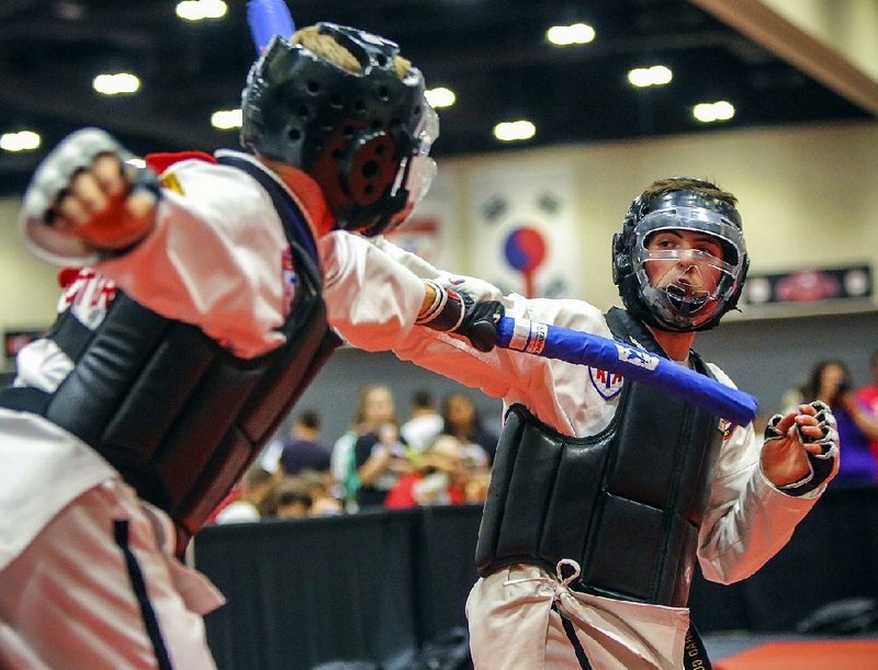 Brad Clemens (right) of Painsville, Ohio, and Andrew Vorster of McKinney, Texas, compete in combat sparring at a previous American Taekwondo Association World Expo. This year’s expo continues through Sunday at Little Rock’s Statehouse Convention Center.  