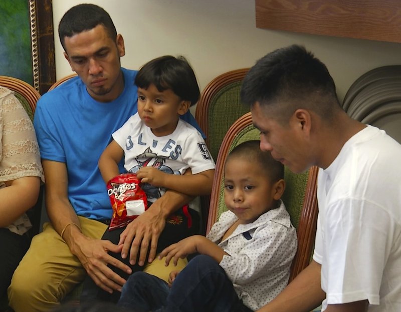 In this image taken from video, Javier Garrido Martinez, left and Alan Garcia, right, sit with their 4-year-sons at a news conference in New York, Wednesday, July 11, 2018. They men were reunited with their children after almost two months of separation, Authorities took their boys them when they stopped at the U.S. southern border. (AP Photo/Robert Bumsted)

