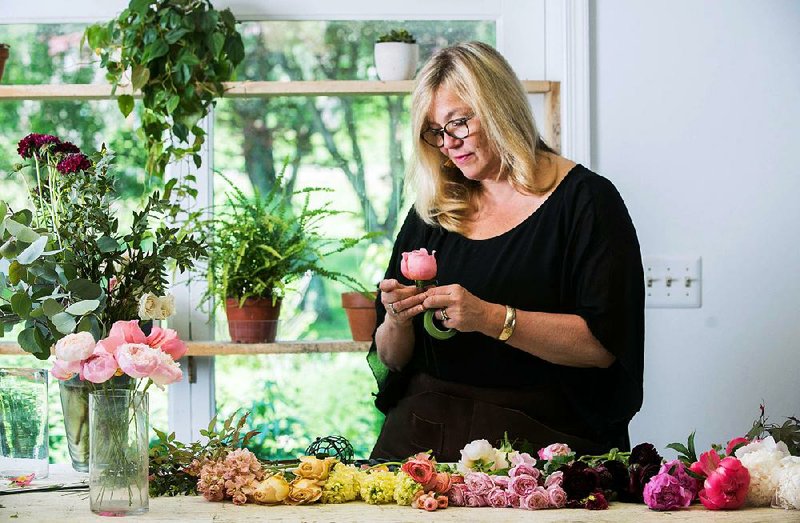 Holly Chapple lays out and inspects each flower that goes into a bridal bouquet while working in her floral design studio in Loudoun County, Va. 
