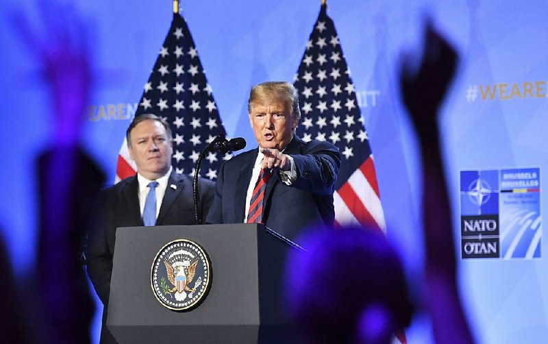 With Secretary of State Mike Pompeo beside him Thursday, President Donald Trump says at a news conference after a meeting of NATO leaders in Brussels that he believes in NATO but Western allies need to increase their defense spending. 