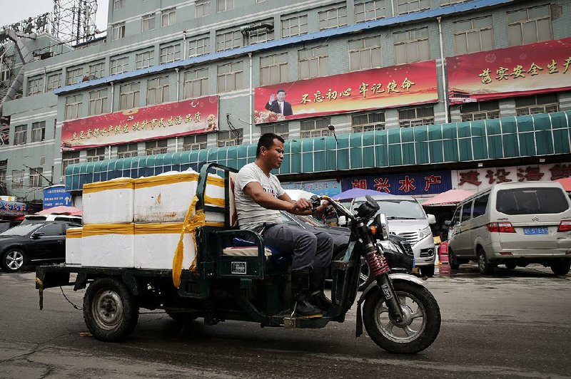 A seafood delivery driver works Thursday in Beijing where some merchants say they have begun buying seafood, soybeans and other products from countries other than the United States because of U.S. tariffs. 