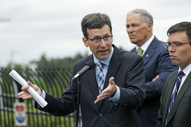  In this June 21, 2018, file photo, Washington state Attorney General Bob Ferguson, left, speaks as Washington Gov. Jay Inslee, center, and Solicitor General Noah Purcell look on at a news conference in SeaTac, Wash. Seven national fast-food chains have agreed to end policies that block workers from changing branches, limiting their wages and job opportunities, under the threat of legal action from the state of Washington.  (AP Photo/Elaine Thompson, File)