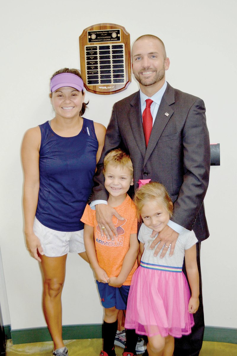 Circuit Judge Troy Braswell Jr. stands in the Conway Police Department with his wife, Karla, and their two children, Trey, 6, and Mia, 4. The plaque on the wall has Braswell’s name engraved as Outstanding Community Leader, presented to him June 29 by the Conway Morning Rotary Club.