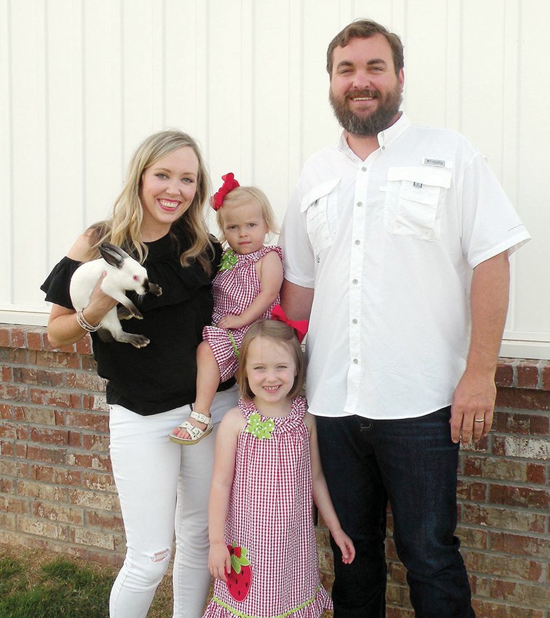 The Michael Lee family of Conway is the 2018 Faulkner County Farm Family of the Year. The family includes, from left, Lauren, holding her 2-year-old daughter, Adelaide Grace, and a Himalayan rabbit; Mary Elliott, who will be 5 in the fall; and Michael. Their farm is diversified, including row cropland that is rented, a cow/calf operation and a pecan orchard.