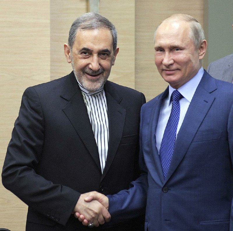 Russian President Vladimir Putin, right, shakes hands with Ali Akbar Velayati, a senior adviser to Iran's Supreme Leader Ayatollah Ali Khamenei, at Novo-Ograyovo outside in Moscow, Russia, Thursday, July 12, 2018. 