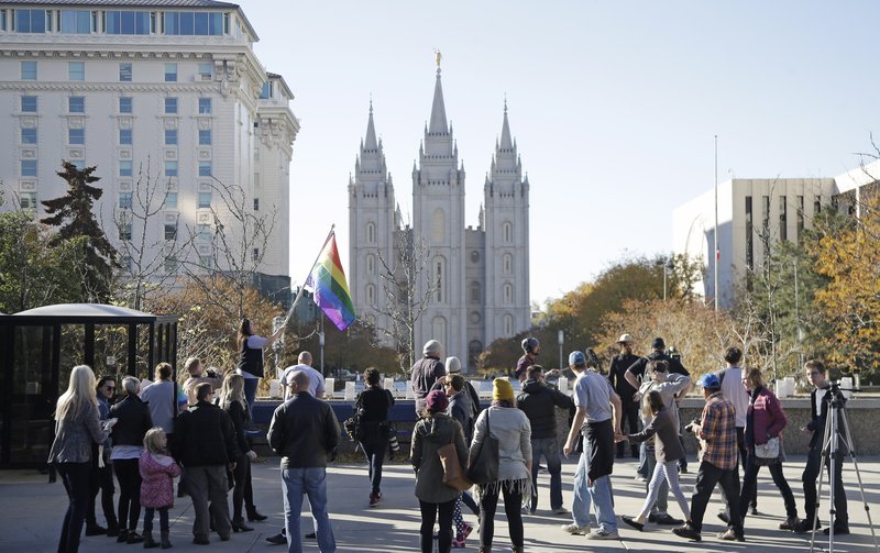 In this Nov. 14, 2015, file photo, people walk past the Salt Lake Temple after mailing resignation letters during a mass resignation from the Church of Jesus Christ of Latter-day Saints in Salt Lake City. The Mormon church's massive genealogical database will begin accepting submissions of names of people from same-sex relationships sometime next year. The move doesn't foreshadow any change to long-standing church opposition to gay marriage, but it is being done to ensure the databank has as much information as possible for researchers, according to a statement from The Church of Jesus Christ of Latter-day Saints.