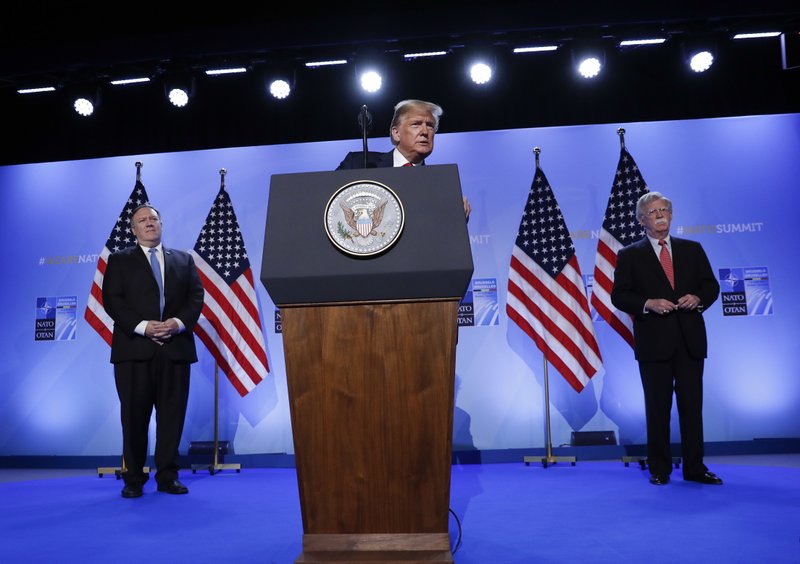 U.S. President Donald Trump speaks during a news conference before departing the NATO Summit in Brussels, Belgium, Thursday, July 12, 2018. Secretary of State Mike Pompeo is at left and National Security Adviser John Bolton, right. (AP Photo/Pablo Martinez Monsivais)