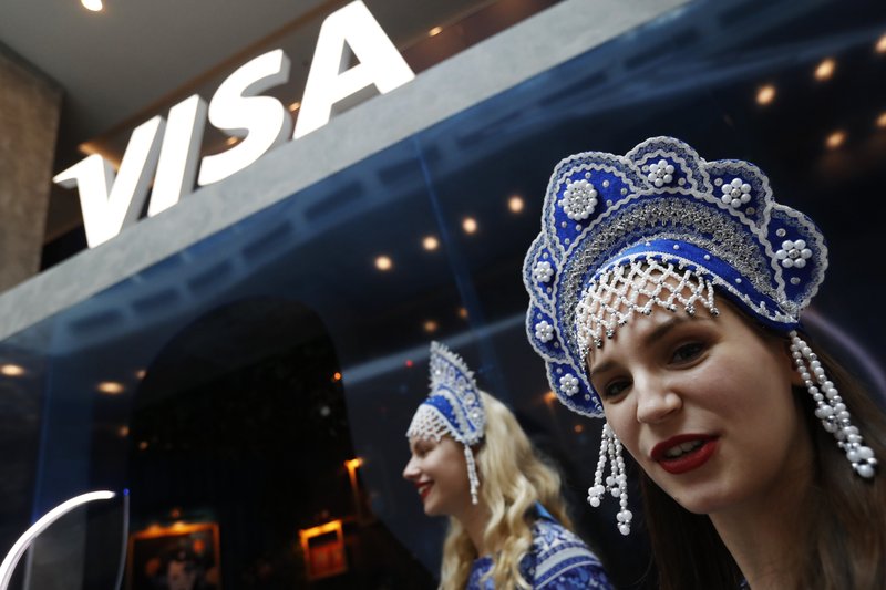 The Associated Press TRADITIONAL MARKETING: In this July 5 photo, women wearing traditional head dresses wait to greet Visa cardholders who won trips to the 2018 soccer World Cup, at the Marriott Novy Arbat Hotel, taken over by visa for the duration of the World Cup in Moscow, Russia.