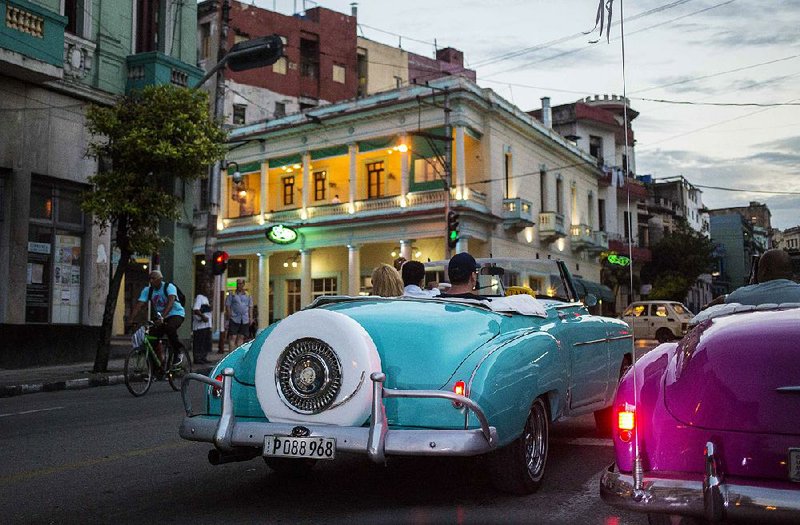 In this June photo, tourists ride classic American convertibles in Havana where the government will allow new restaurants, bed-and-breakfasts and transportation businesses by the end of the year.  