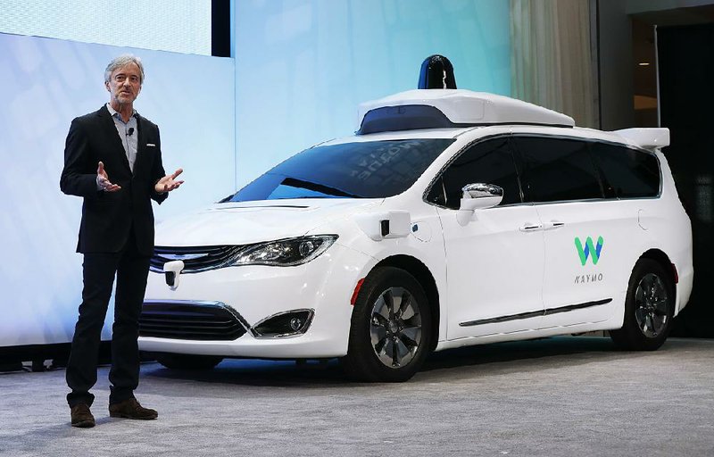 In this January photo, CEO of Waymo John Krafcik introduces a Chrysler Pacifi ca hybrid, outfitted with Waymo’s sensors and radar, at the North American International Auto Show in Detroit. 