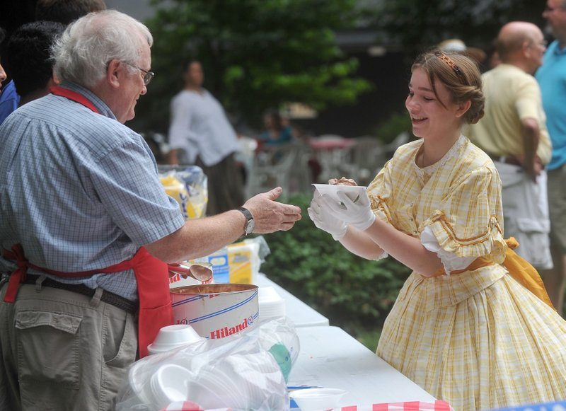 File photo Maylon Rice of Fayetteville (left) serves up a bowl of ice cream during a previous Washington County Historical Society Ice Cream Social. This year's event, the 47th, is set from 3 to 6 p.m. Aug. 18 at the historical society's home, Headquarters House, 118 W. Dickson St. in Fayetteville. Cost is $5 for adults, $2.50 for children ages 6-12 or $15 for a family and includes cake, ice cream and entertainment. Information: (479) 521-2970.