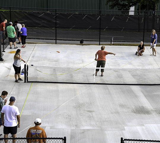 The Sentinel-Record/Grace Brown NEW COURTS: Members of the Hot Springs Pickleball Club work to lay out lines for a newly completed pickleball court park installed in front of Tanners Team Sports Inc., 736 Mid-America Blvd., as a way for the company to give back to the community and promote its new line of pickleball products. Four state-of-the-art outdoor pickleball courts at the location are for the team and public to use.