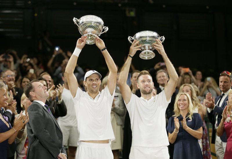 The Associated Press SINGLE DOUBLE: Americans Mike Bryan, left, and Jack Sock hold up their trophies after defeating Raven Klaasen and Michael Venus Saturday in the men's doubles final match at the Championships, Wimbledon in London.