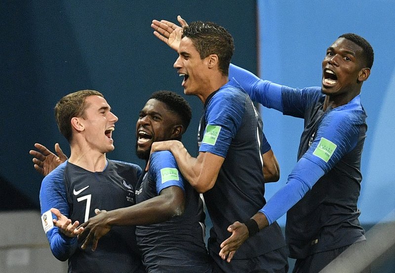 France's Samuel Umtiti, second from left, is congratulated by his teammates France's Antoine Griezmann, Raphael Varane and Paul Pogba, from left, after scoring the opening goal during the semifinal match between France and Belgium at the 2018 soccer World Cup in the St. Petersburg Stadium in St. Petersburg, Russia, Tuesday, July 10, 2018. (AP Photo/Martin Meissner)