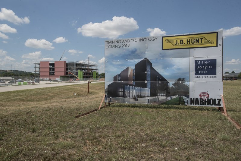 NWA Democrat-Gazette/SPENCER TIREY A sign shows the finished Training and Technology building that J.B. Hunt is having constructed in the background, near the main camps of their Lowell headquaters.