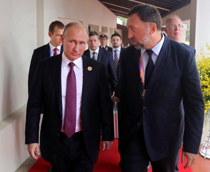 FILE - In this Nov. 10, 2017, file photo, Russia's President Vladimir Putin, left, and Oleg Deripaska, right, attend the APEC Business Advisory Council dialogue in Danang, Vietnam
