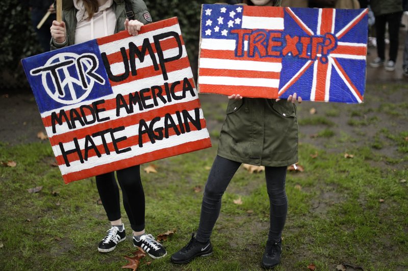 In this Feb. 4, 2017 file photo, demonstrators hold placards as they take part in a protest outside the U.S. embassy in London, against U.S. President Donald Trump's ban on travellers and immigrants from seven predominantly Muslim countries entering the U.S. Trump's recent lament this week that immigration is "changing the culture" of Europe is echoing rising anti-immigrant feelings on both sides of the Atlantic, where Europe and the United States are going through transformative demographic changes that makes some of the white majority uncomfortable. (AP Photo/Matt Dunham, file)