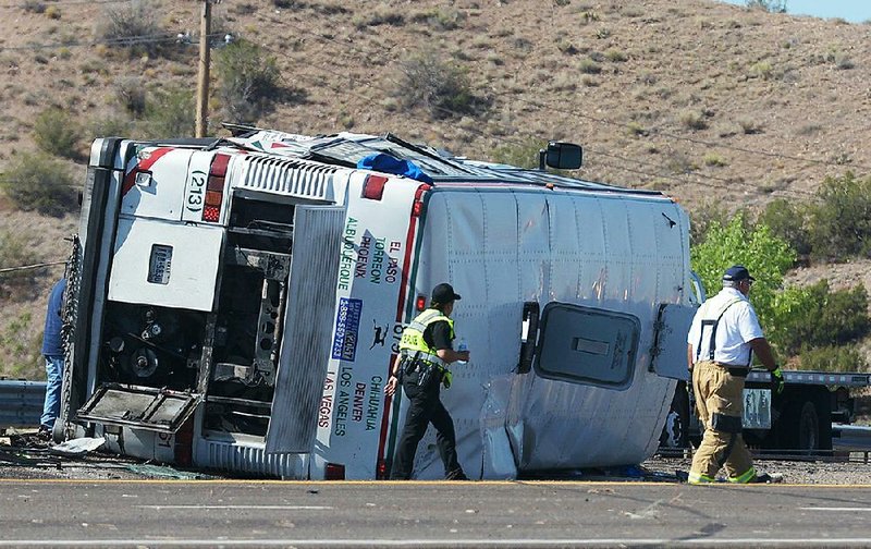 Emergency personnel work at the scene of a deadly multi-vehicle crash involving a bus that occurred on Interstate 25 north of Bernalillo, N.M on Sunday.  