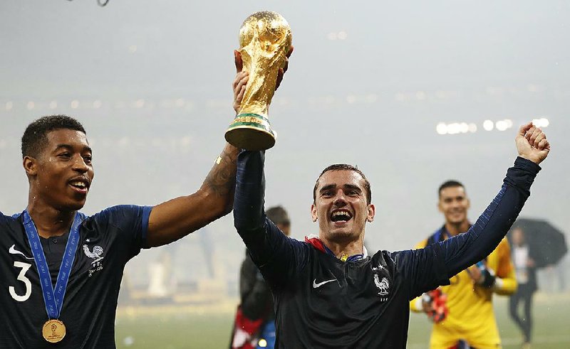 France’s Antoine Griezmann (right) with teammate France’s Presnel Kimpembe after France defeated Croatia 4-2 to win the World Cup on Sunday in Moscow. Griezmann, whose father is from Germany and mother is from Portugal, is one of several players for France whose families come from different countries.  