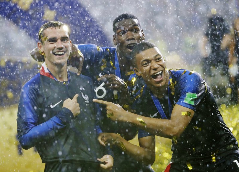 France's Antoine Griezmann, points to two stars on his jersey indicating two world cup wins, as he celebrates with Paul Pogba and Kylian Mbappe after the final match between France and Croatia at the 2018 soccer World Cup in the Luzhniki Stadium in Moscow, Russia, Sunday, July 15, 2018. France won the final 4-2. (AP Photo/Matthias Schrader)