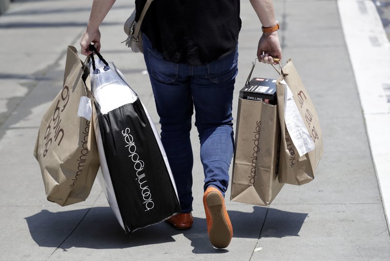 In this July 3, 2018, photo, a shopper carries bags in San Francisco. On Monday, July 16, the Commerce Department releases U.S. retail sales data for June. (AP Photo/Marcio Jose Sanchez)

